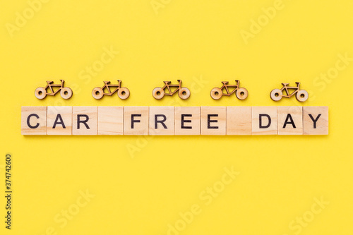 Text Car Free Day and small bicycles on yellow background. Concept of world car free day on September 22. Top view