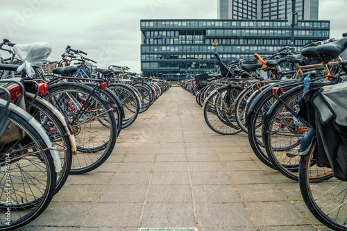 Many bicycles parked bike parking area in Amsterdam, The Netherlands.