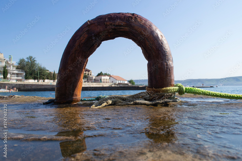 Fototapeta premium An old rusty metal device for mooring a boat on the pier.