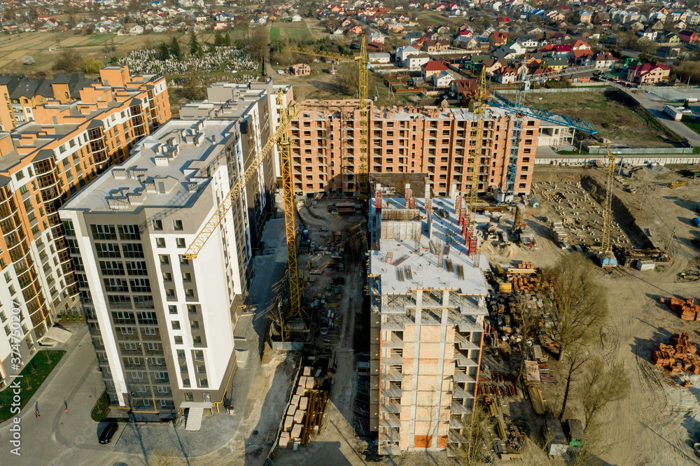 Fototapeta premium Construction and construction of high-rise buildings, the construction industry with working equipment and workers. View from above, from above. Background and texture