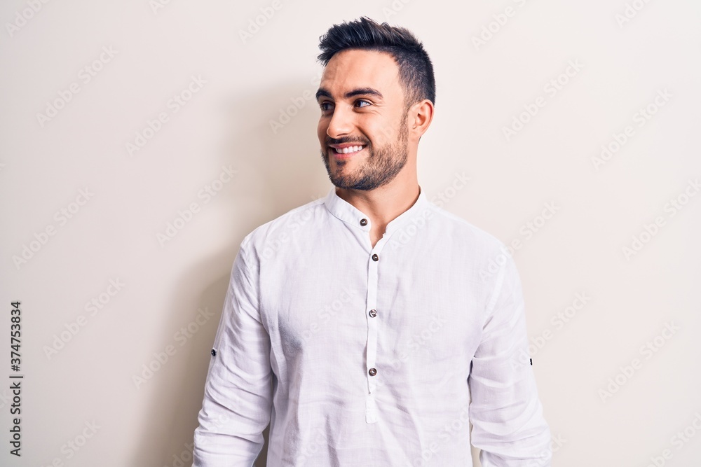 Young handsome man with beard wearing casual t-shirt standing over white background looking to side, relax profile pose with natural face and confident smile. Young handsome man with beard wearing casual t-shirt standing over white background looking to side, relax profile pose with natural face and confident smile.