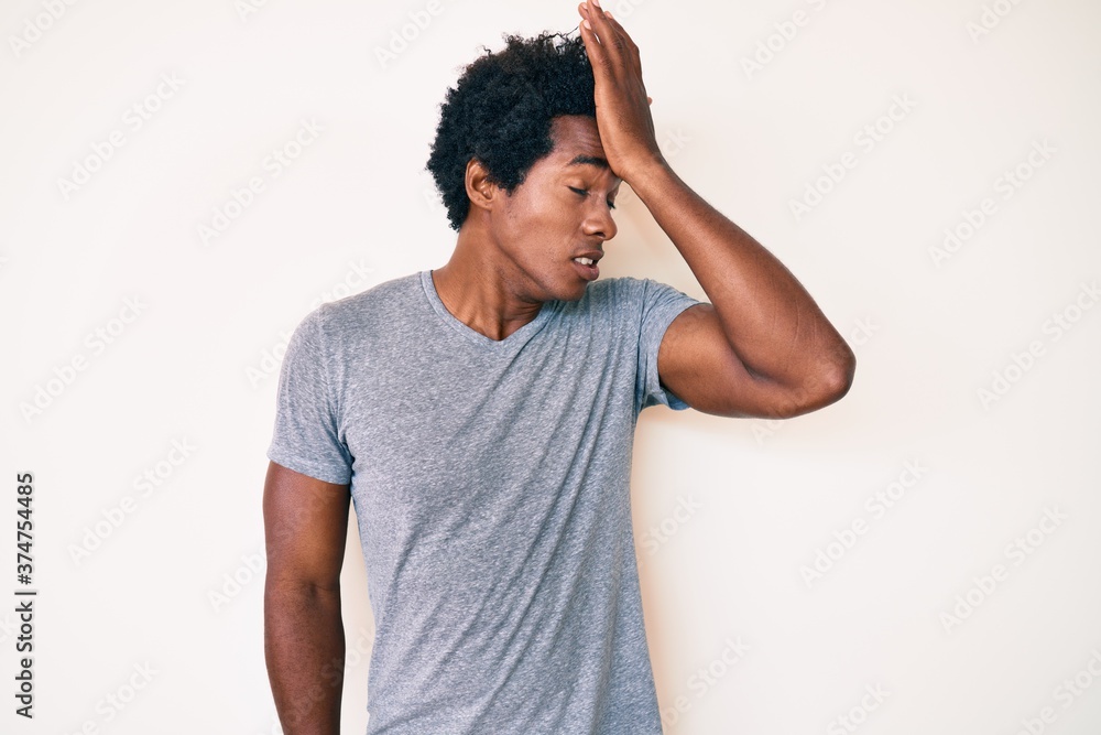 Handsome african american man with afro hair wearing casual clothes surprised with hand on head for mistake, remember error. forgot, bad memory concept. Handsome african american man with afro hair wearing casual clothes surprised with hand on head for mistake, remember error. forgot, bad memory concept.