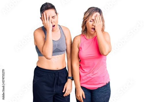 Couple of women wearing sportswear yawning tired covering half face, eye and mouth with hand. face hurts in pain.