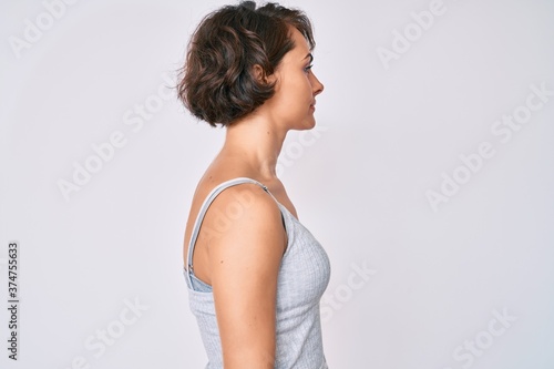 Young hispanic woman wearing casual clothes looking to side, relax profile pose with natural face with confident smile.