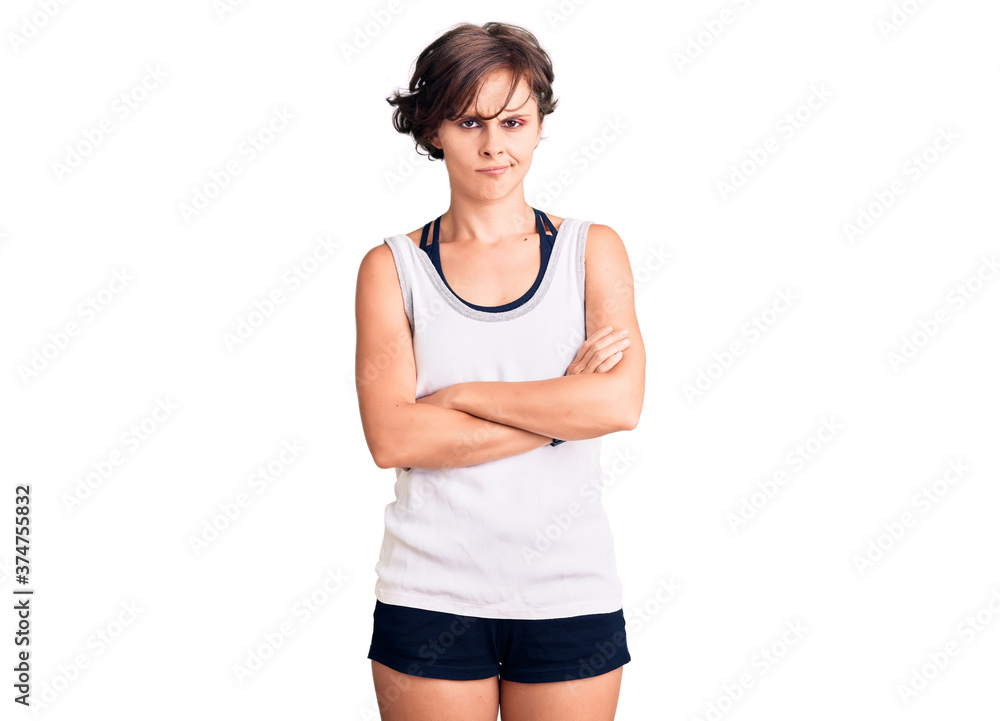 Beautiful young woman with short hair wearing casual sport clothes skeptic and nervous, disapproving expression on face with crossed arms. negative person. Beautiful young woman with short hair wearing casual sport clothes skeptic and nervous, disapproving expression on face with crossed arms. negative person.