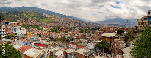 Tablou pe pânză Panorama landscape of city view of Comuna 13 favela with brick houses and cloudy