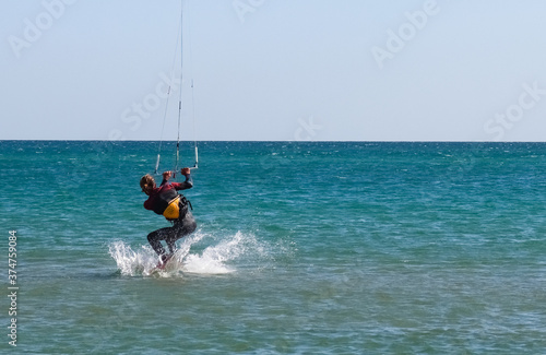 Photography a kitesurfer surfing on the smooth azure water