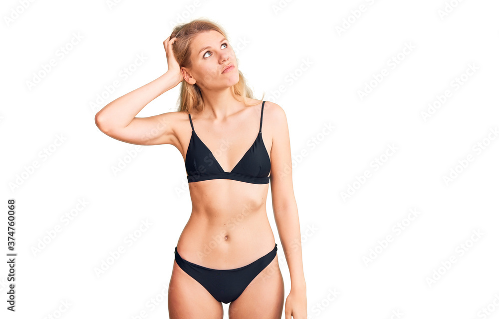 Young beautiful blonde woman wearing bikini confuse and wondering about question. uncertain with doubt, thinking with hand on head. pensive concept. Young beautiful blonde woman wearing bikini confuse and wondering about question. uncertain with doubt, thinking with hand on head. pensive concept.