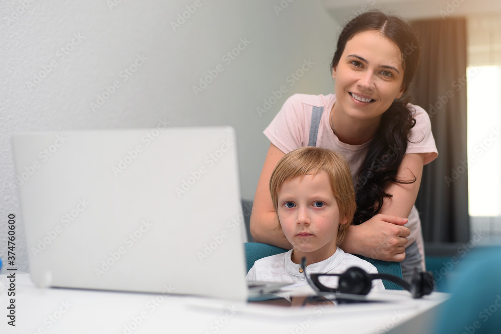 Coronavirus Outbreak. Lockdown and school closures. Mother helping her son studying online classes at home. COVID-19 pandemic forces children and teachers online learning Coronavirus Outbreak. Lockdown and school closures. Mother helping her son studying online classes at home. COVID-19 pandemic forces children and teachers online learning