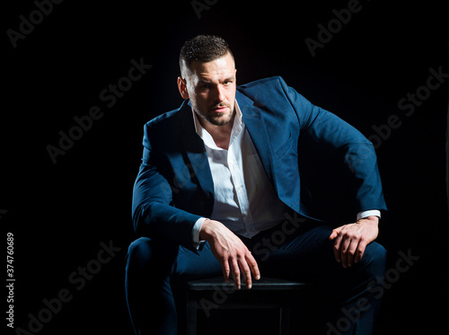 Confident elegant handsome young business man in a studio wearing a suit.