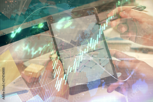 Double exposure of man's hands holding and using a phone and financial chart drawing. Market analysis concept.