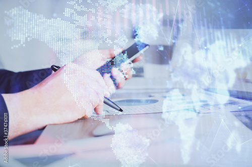 Double exposure of man's hands holding and using a phone and financial graph drawing. Analysis concept.