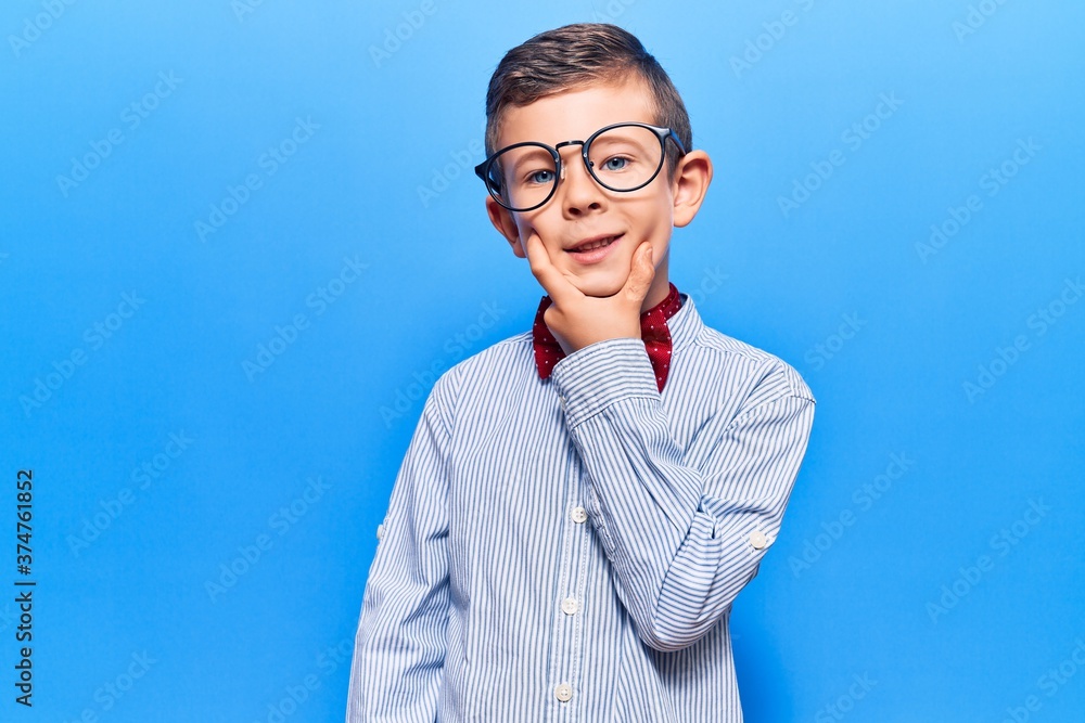 Cute blond kid wearing nerd bow tie and glasses looking confident at the camera smiling with crossed arms and hand raised on chin. thinking positive. Cute blond kid wearing nerd bow tie and glasses looking confident at the camera smiling with crossed arms and hand raised on chin. thinking positive.