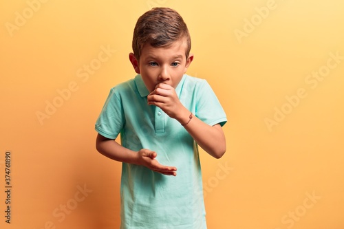 Cute blond kid wearing casual clothes feeling unwell and coughing as symptom for cold or bronchitis. health care concept.