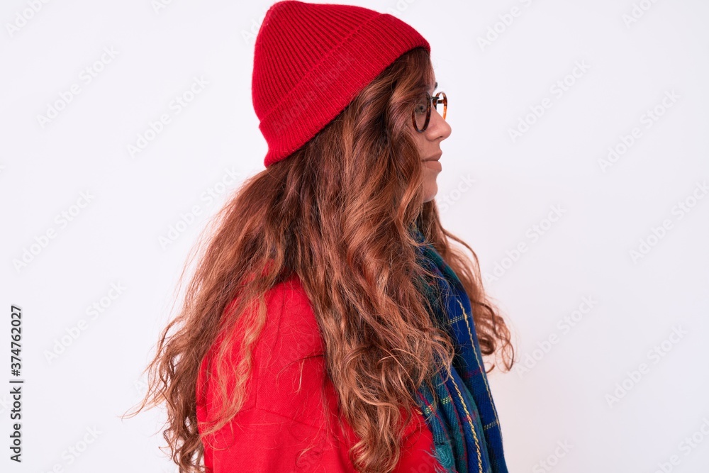 Young beautiful woman wearing casual winter scarf and glasses looking to side, relax profile pose with natural face with confident smile.