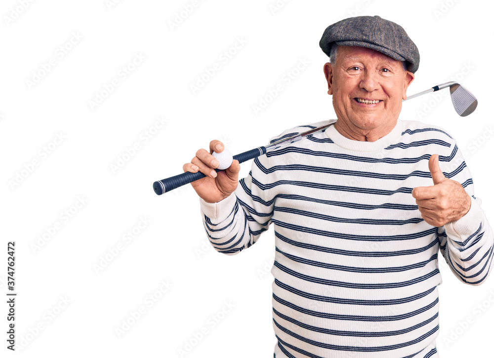 Senior handsome grey-haired man holding golf club and ball smiling happy and positive, thumb up doing excellent and approval sign Senior handsome grey-haired man holding golf club and ball smiling happy and positive, thumb up doing excellent and approval sign