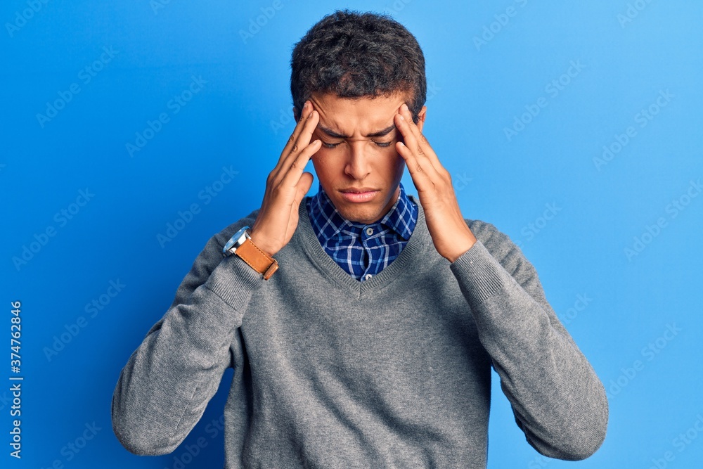 Young african amercian man wearing casual clothes suffering from headache desperate and stressed because pain and migraine. hands on head. Young african amercian man wearing casual clothes suffering from headache desperate and stressed because pain and migraine. hands on head.