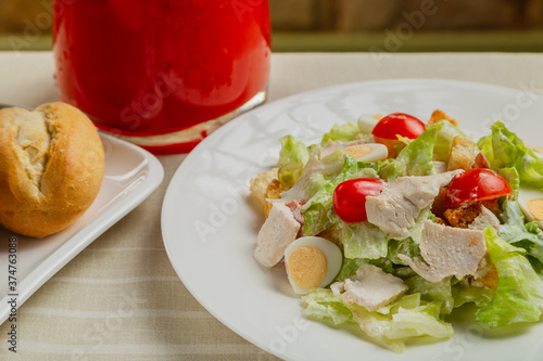 Fresh caesar salad in a white plate on the table.