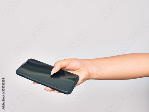 Hand of caucasian young woman holding smartphone showing screen over isolated white background