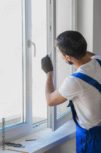 Worker in overalls preparing to install a window