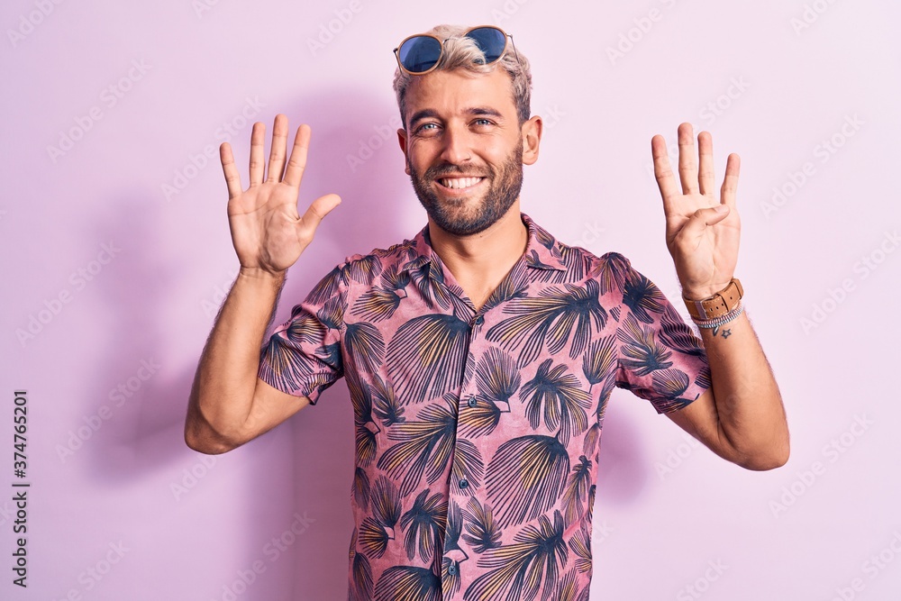 Handsome blond man on vacation wearing casual shirt and sunglasses over pink background showing and pointing up with fingers number nine while smiling confident and happy. Handsome blond man on vacation wearing casual shirt and sunglasses over pink background showing and pointing up with fingers number nine while smiling confident and happy.