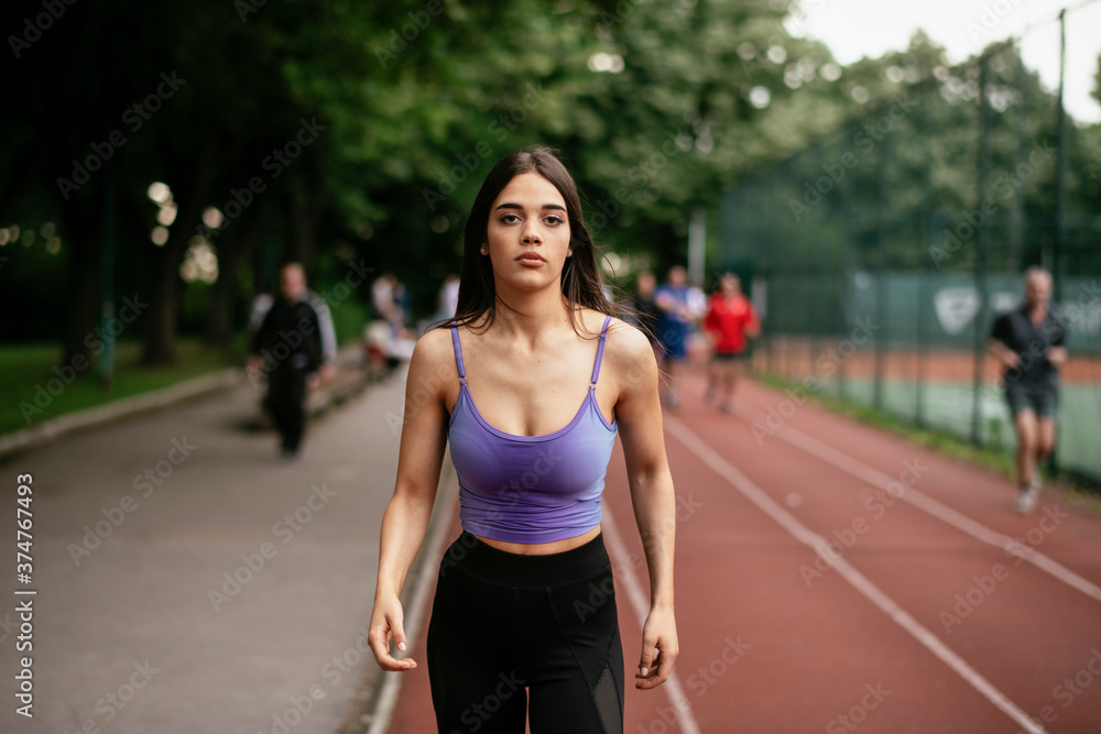 Happy athletic woman running in nature in the morning. Young woman training outdoors....