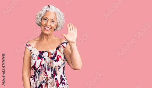 Senior grey-haired woman wearing casual clothes showing and pointing up with fingers number five while smiling confident and happy.