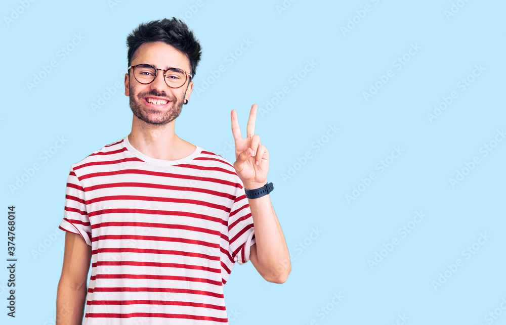Young hispanic man wearing casual clothes showing and pointing up with fingers number two while smiling confident and happy. Young hispanic man wearing casual clothes showing and pointing up with fingers number two while smiling confident and happy.