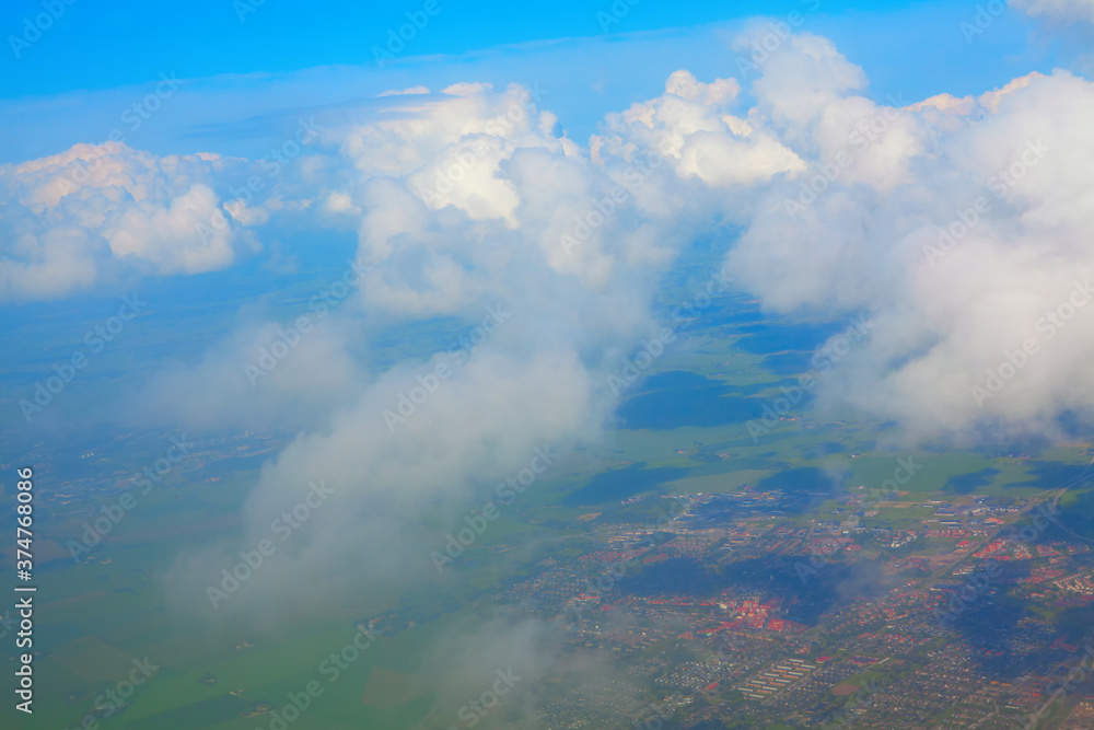 Flying over the clouds , aerial city view 