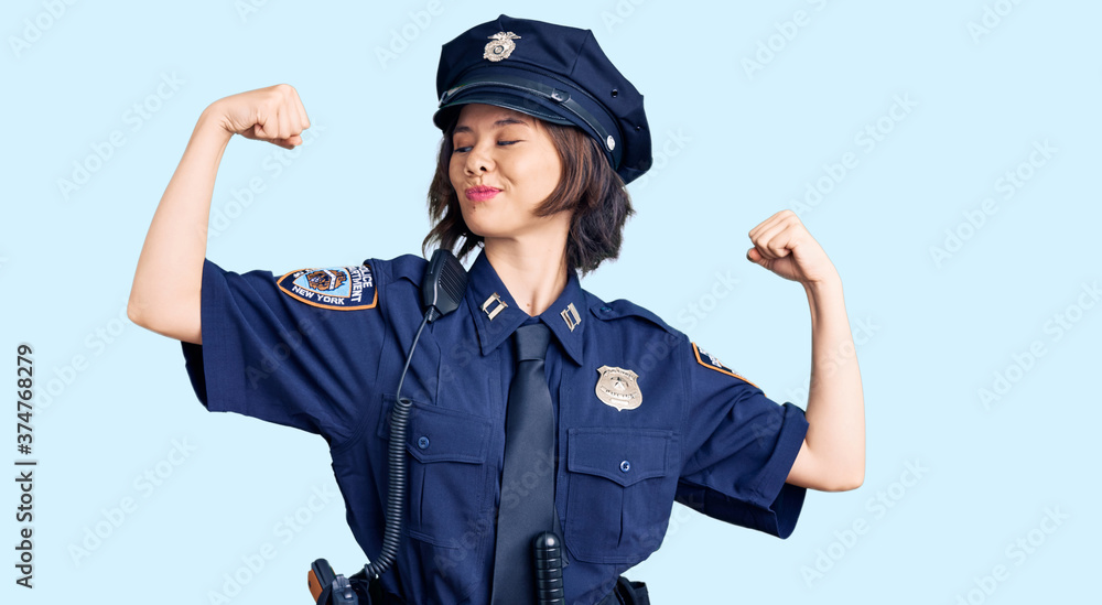 Young beautiful girl wearing police uniform showing arms muscles smiling proud. fitness concept. Young beautiful girl wearing police uniform showing arms muscles smiling proud. fitness concept.