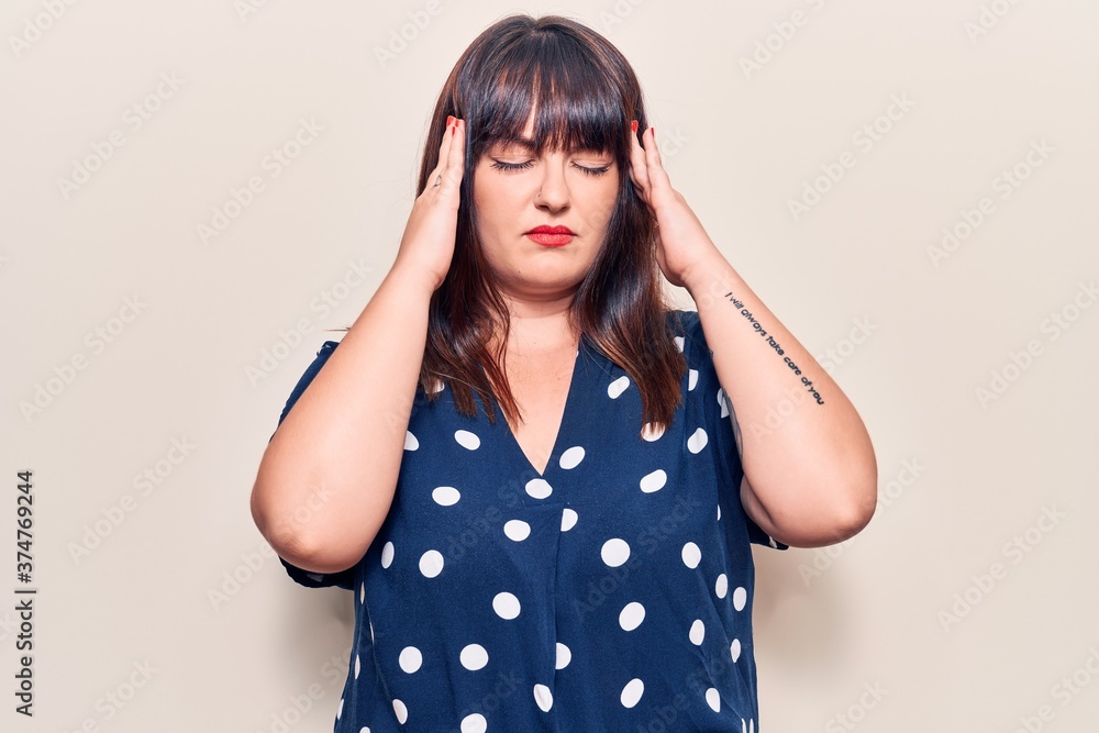 Young plus size woman wearing casual clothes suffering from headache desperate and stressed because pain and migraine. hands on head. Young plus size woman wearing casual clothes suffering from headache desperate and stressed because pain and migraine. hands on head.