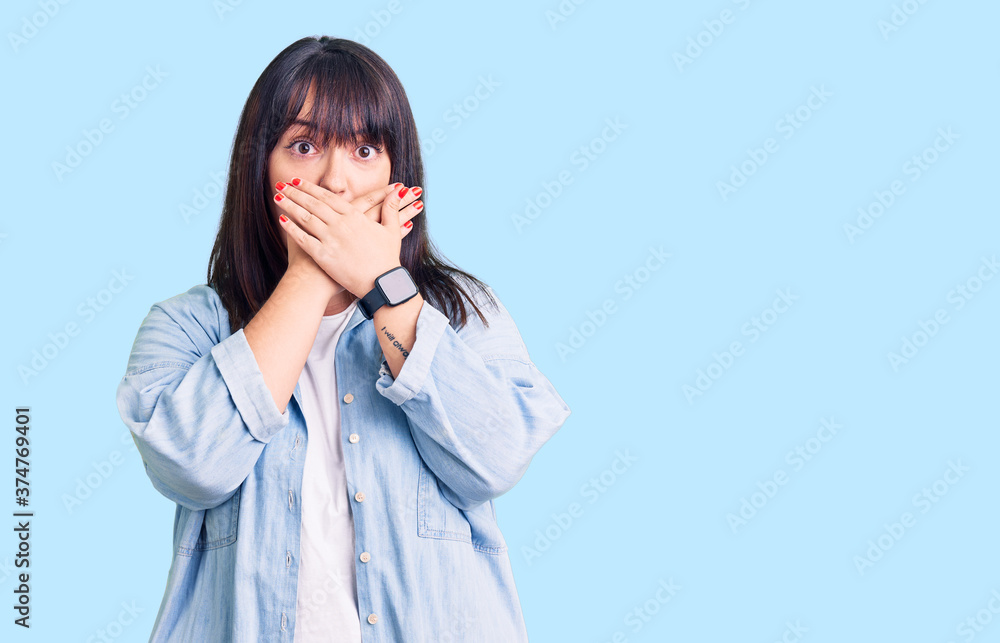Young plus size woman wearing casual clothes shocked covering mouth with hands for mistake. secret concept. Young plus size woman wearing casual clothes shocked covering mouth with hands for mistake. secret concept.