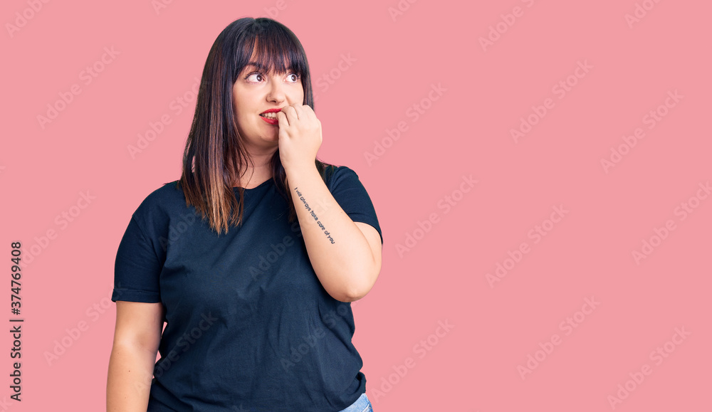 Young plus size woman wearing casual clothes looking stressed and nervous with hands on mouth biting nails. anxiety problem. Young plus size woman wearing casual clothes looking stressed and nervous with hands on mouth biting nails. anxiety problem.
