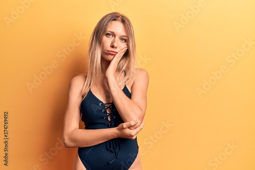 Young beautiful blonde girl wearing swimwear thinking looking tired and bored with depression problems with crossed arms.