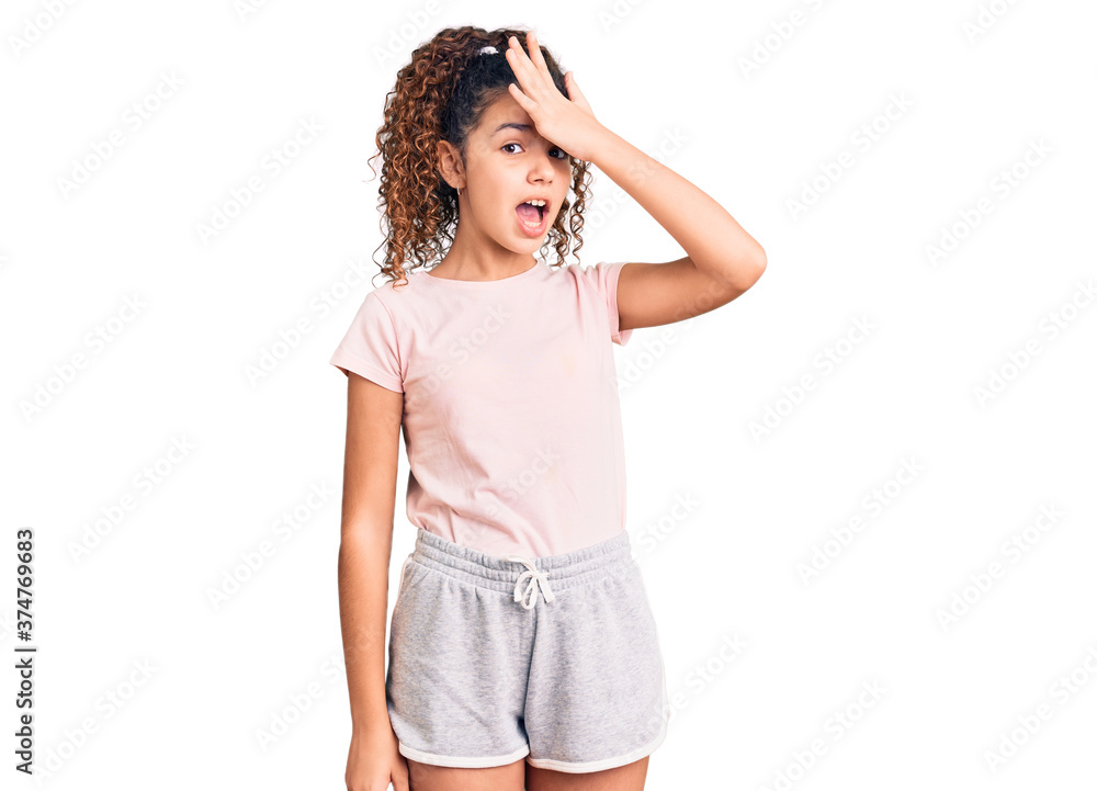Beautiful kid girl with curly hair wearing casual clothes surprised with hand on head for mistake, remember error. forgot, bad memory concept. Beautiful kid girl with curly hair wearing casual clothes surprised with hand on head for mistake, remember error. forgot, bad memory concept.