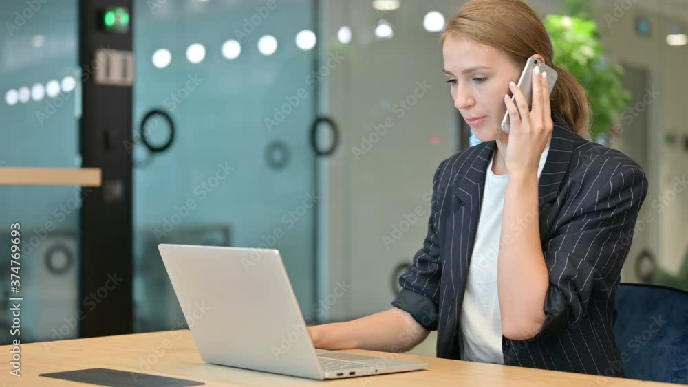 Businesswoman with Laptop Talking on Smartphone Businesswoman with Laptop Talking on Smartphone