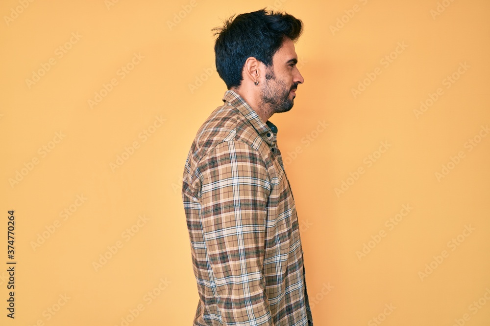 Handsome hispanic man with beard wearing casual clothes looking to side, relax profile pose with natural face with confident smile. Handsome hispanic man with beard wearing casual clothes looking to side, relax profile pose with natural face with confident smile.