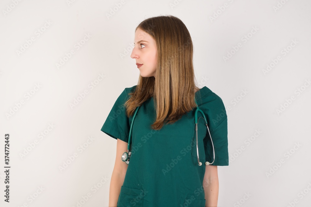 Close up side profile photo Female doctor wearing a green scrubs and stethoscope ready to have a walk. Close up side profile photo Female doctor wearing a green scrubs and stethoscope ready to have a walk.