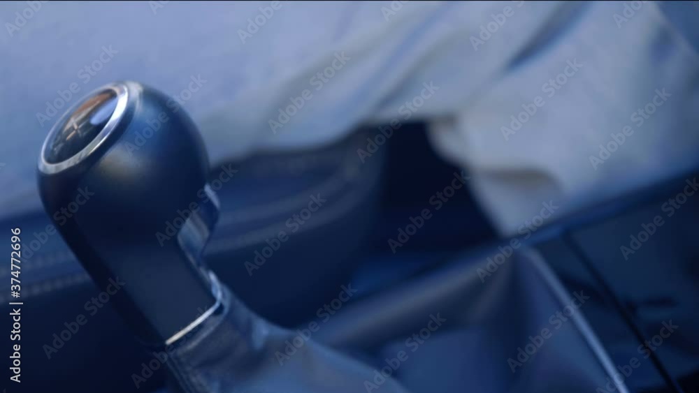 Added shaking from moving the car! The driver's hand takes a shiny black lever and engages the gears in the manual transmission. Closeup Added shaking from moving the car! The driver's hand takes a shiny black lever and engages the gears in the manual transmission. Closeup