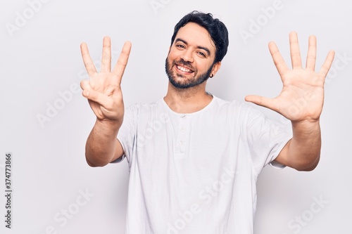 Young hispanic man wearing casual clothes showing and pointing up with fingers number eight while smiling confident and happy. © Krakenimages.com