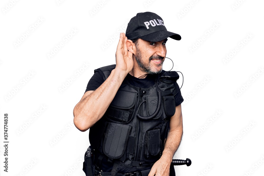 Middle age policeman wearing police uniform and bulletproof vest over white background smiling with hand over ear listening and hearing to rumor or gossip. Deafness concept. Middle age policeman wearing police uniform and bulletproof vest over white background smiling with hand over ear listening and hearing to rumor or gossip. Deafness concept.