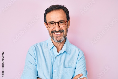 Middle age hispanic man wearing casual clothes and glasses happy face smiling with crossed arms looking at the camera. positive person.