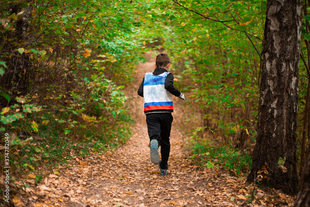 Running competition. A child runs through the forest. Running competition. A child runs through the forest.