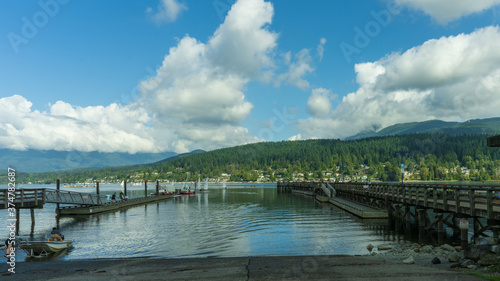 boat slip into tranquil BC ocean inlet surrounded by forests, mountains and beaches