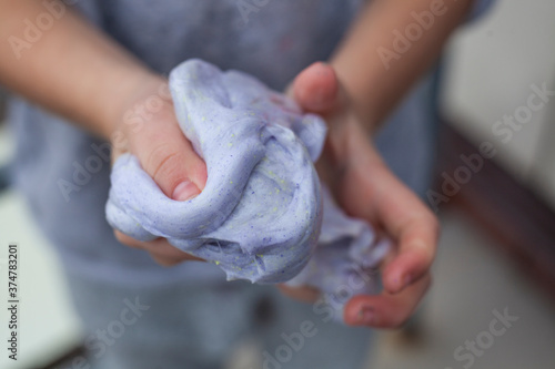The child crumples plasticine in his hands.
