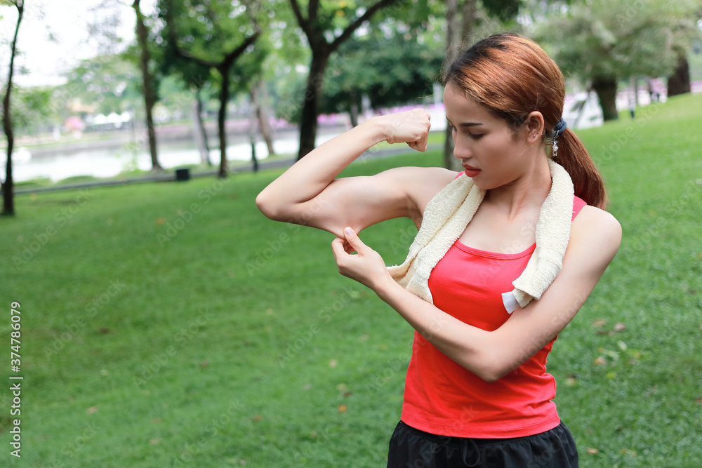 Healthy strong Asian woman in red sportswear showing her hands in natural park. Fitness and lifestyle concept. Healthy strong Asian woman in red sportswear showing her hands in natural park. Fitness and lifestyle concept.