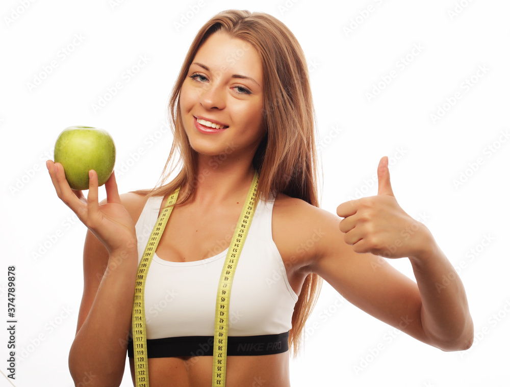 woman in sports wear with green apple on white background woman in sports wear with green apple on white background
