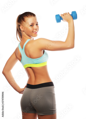 Woman in sport equipment practice with hand weights on white background