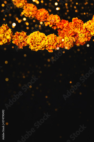 Marigold flowers Garlands and bokeh. Dia de los muertos day, day of the dead or halloween background, copy space photo