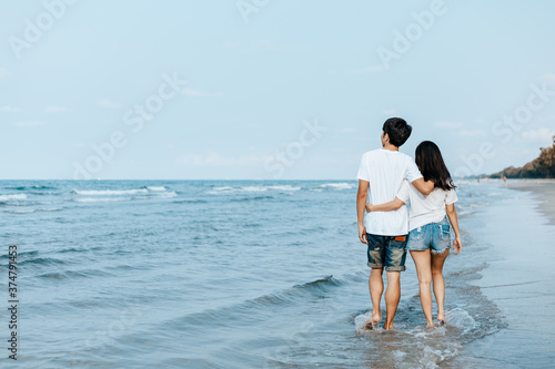 Romantic couple holding hands and walking on beach. Man and woman in love. © Charnchai saeheng